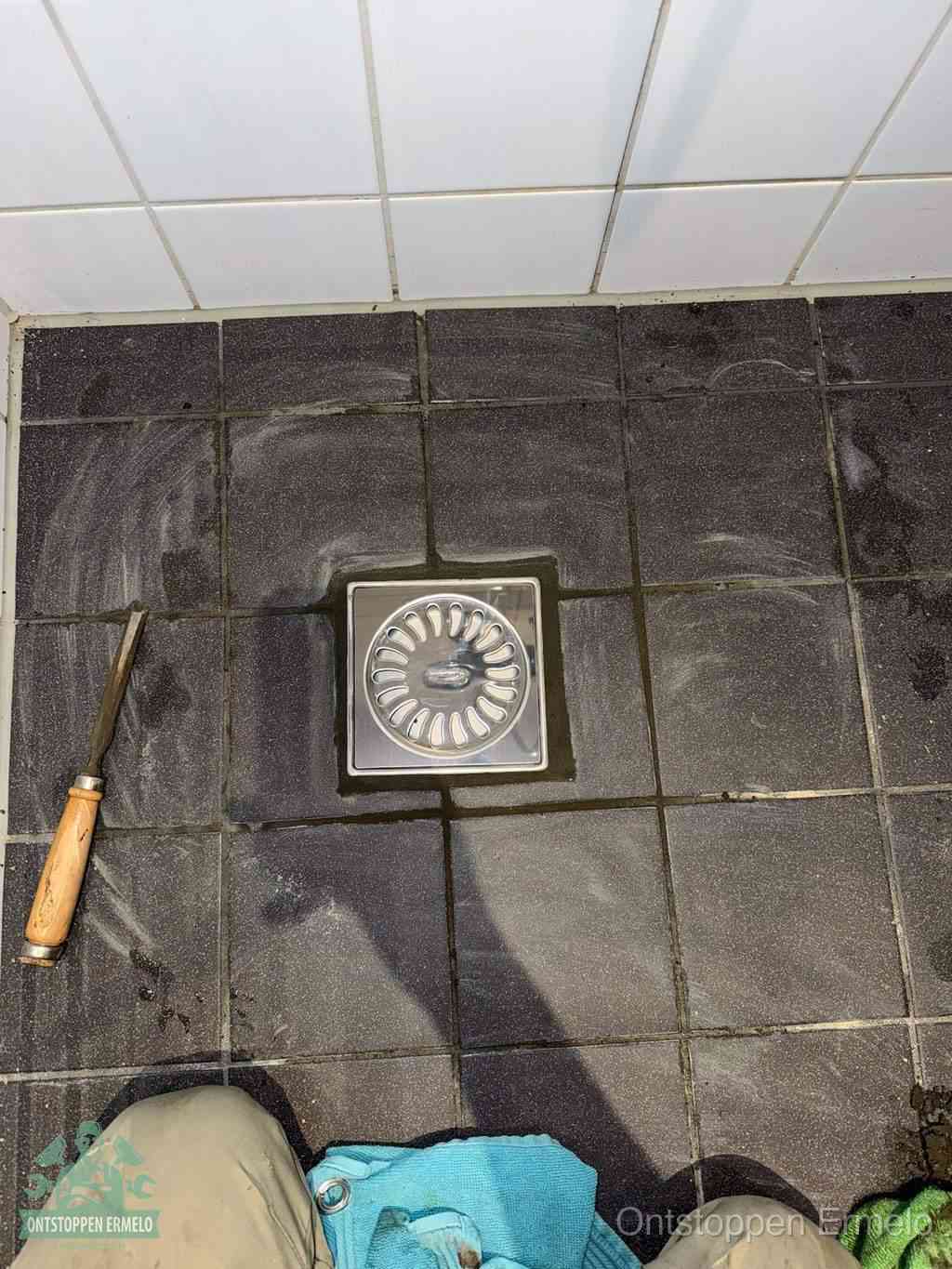Een RVS doucheputje in een betegelde badkamervloer, zelf je badkamer ontstoppen in Ermelo