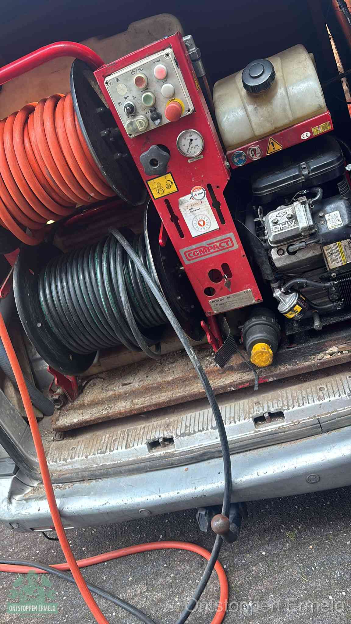 Een rood hogedruk-rioolreinigingstoestel in de laadbak van de bedrijfsbus, apparatuur voor een hardnekkige afvoerverstopping in Ermelo