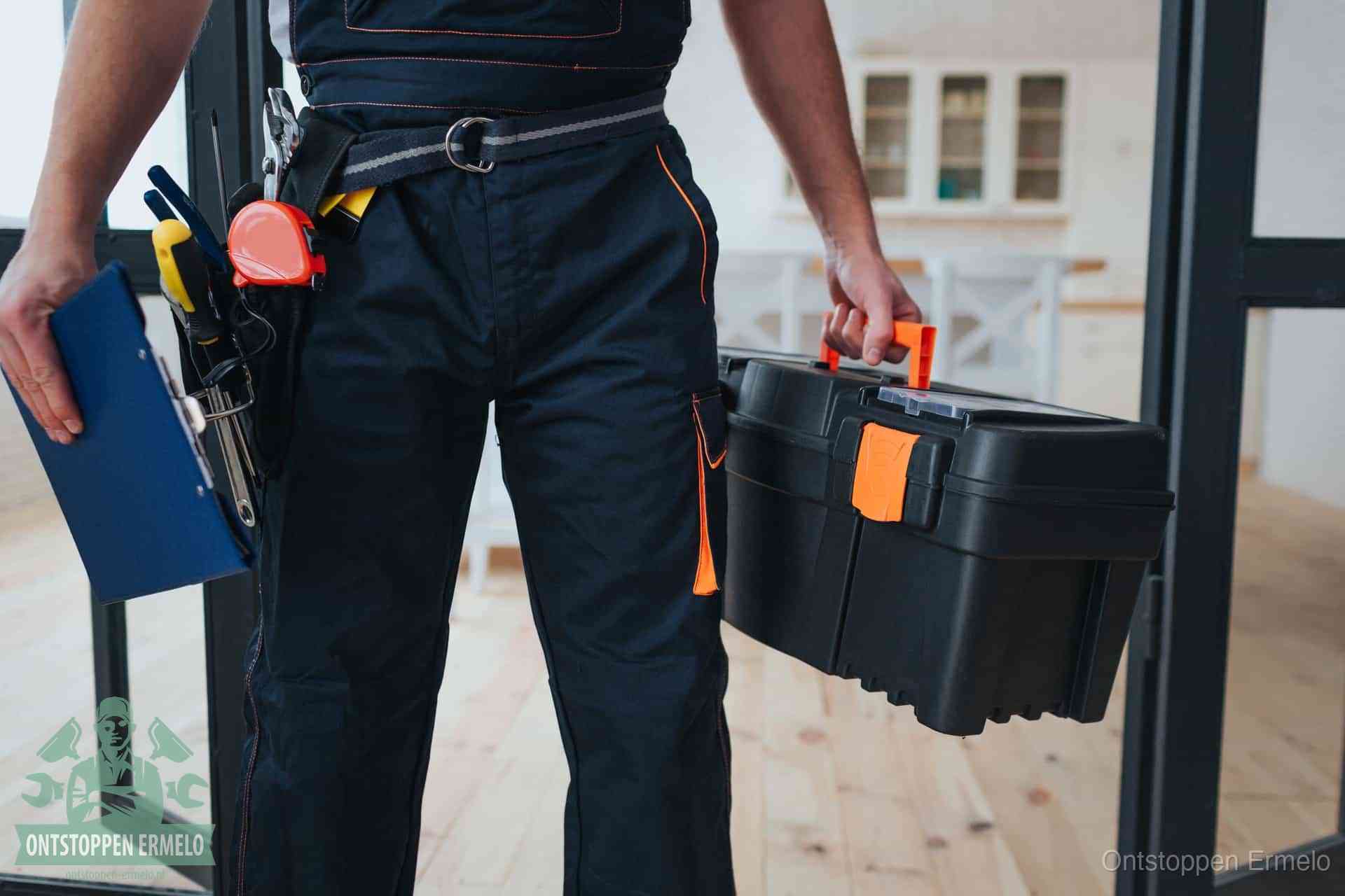 Een monteur met gereedschapsriem en klembord in een keuken, klaar om een transparante prijs voor het gootsteen ontstoppen in Ermelo te geven