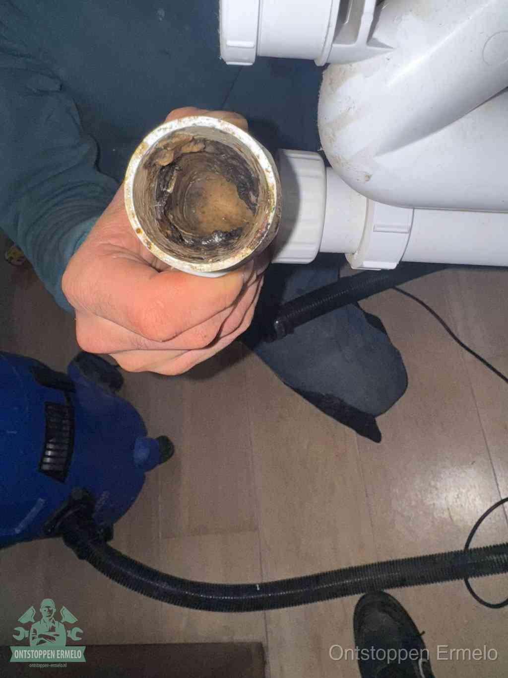 Een losgekoppelde afvoerbuis die van binnen volledig is dichtgeslibd met vet en aanslag, de meest voorkomende oorzaak van een verstopte gootsteen in Ermelo