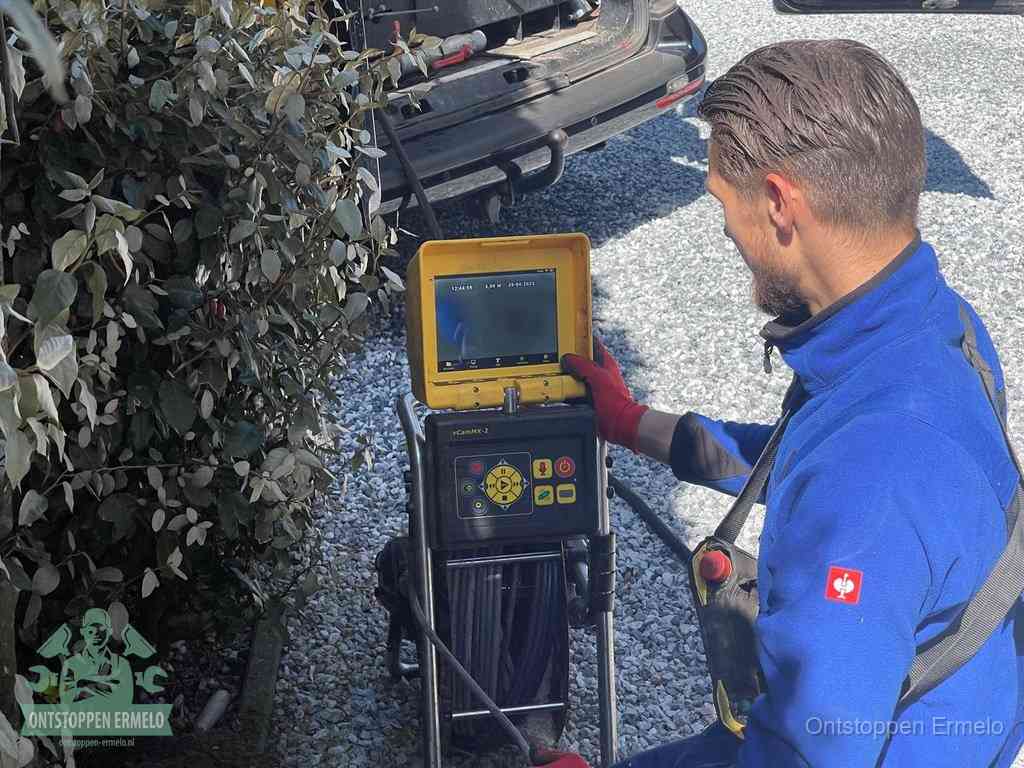 Een monteur bedient een rioolinspectiecamera met monitor en haspel om de verstopping in beeld te brengen in Ermelo