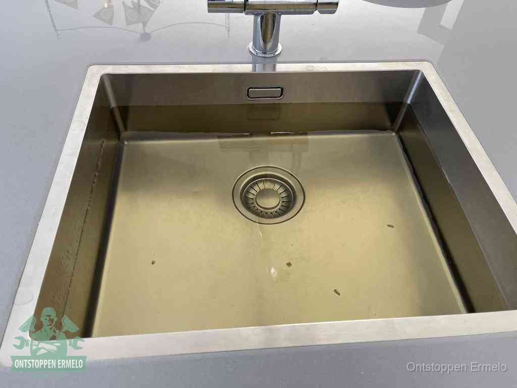 Een RVS spoelbak met stilstaand water dat niet wegloopt, een van de eerste signalen van een beginnende verstopping in Ermelo