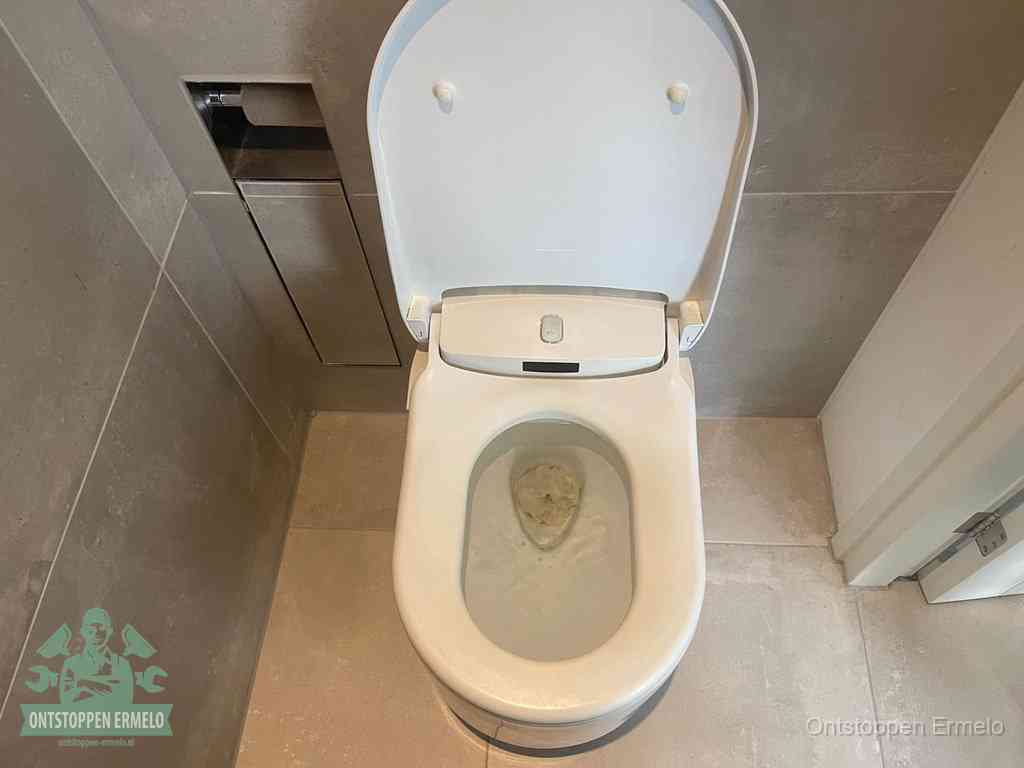 Een wit hangtoilet waarin een prop wc-papier op het water blijft drijven, een duidelijk signaal van een verstopte wc in Ermelo