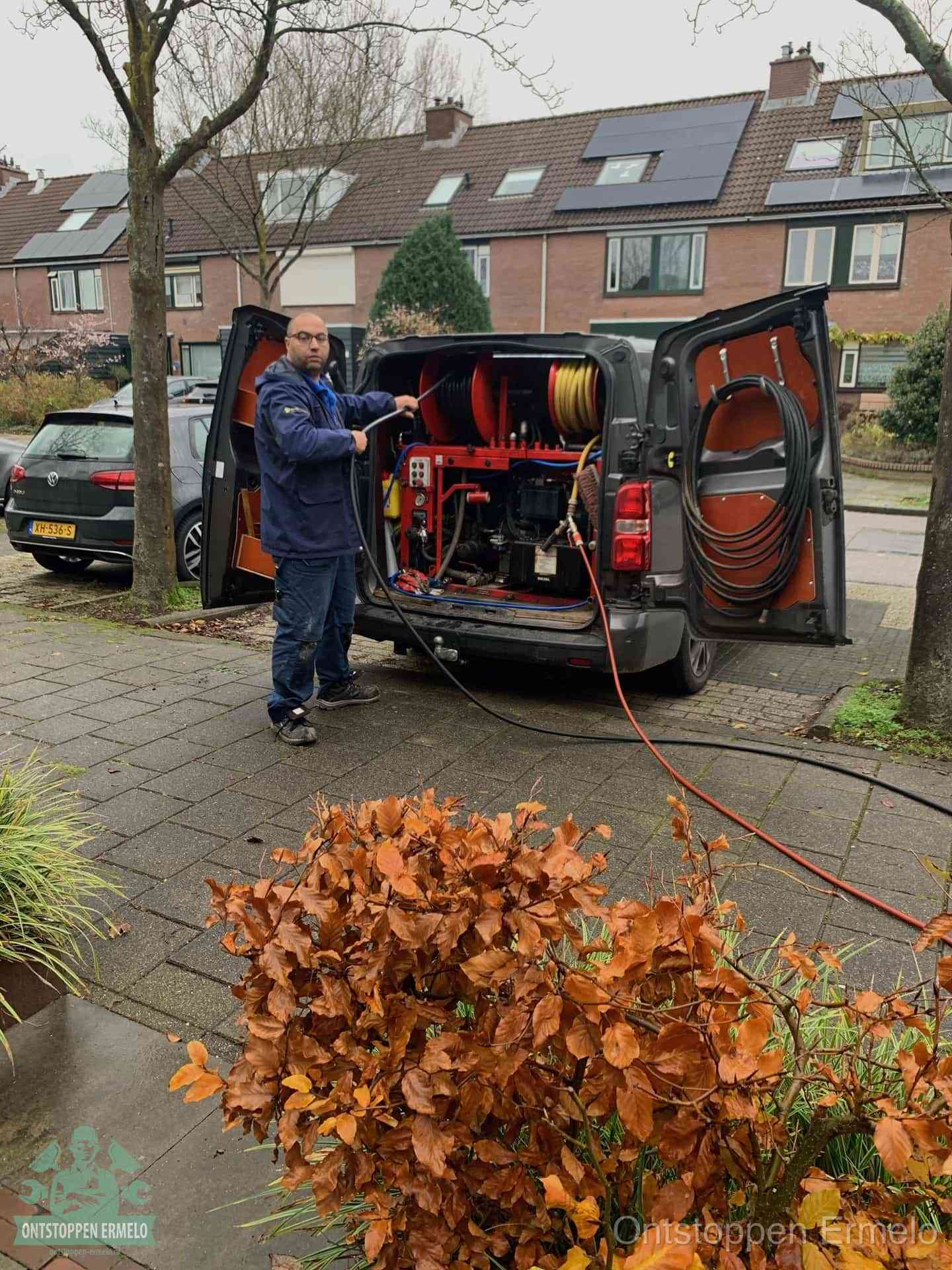 Een monteur staat bij zijn open bestelbus met hogedruk-rioolreinigingsapparatuur, klaar om binnen 30 minuten uit te rukken voor een spoedverstopping in Ermelo