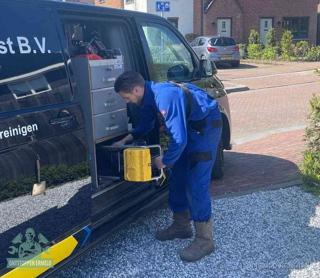 Een monteur pakt gereedschap uit de bedrijfsbus, het moment om een professionele ontstoppingsdienst in te schakelen in Ermelo